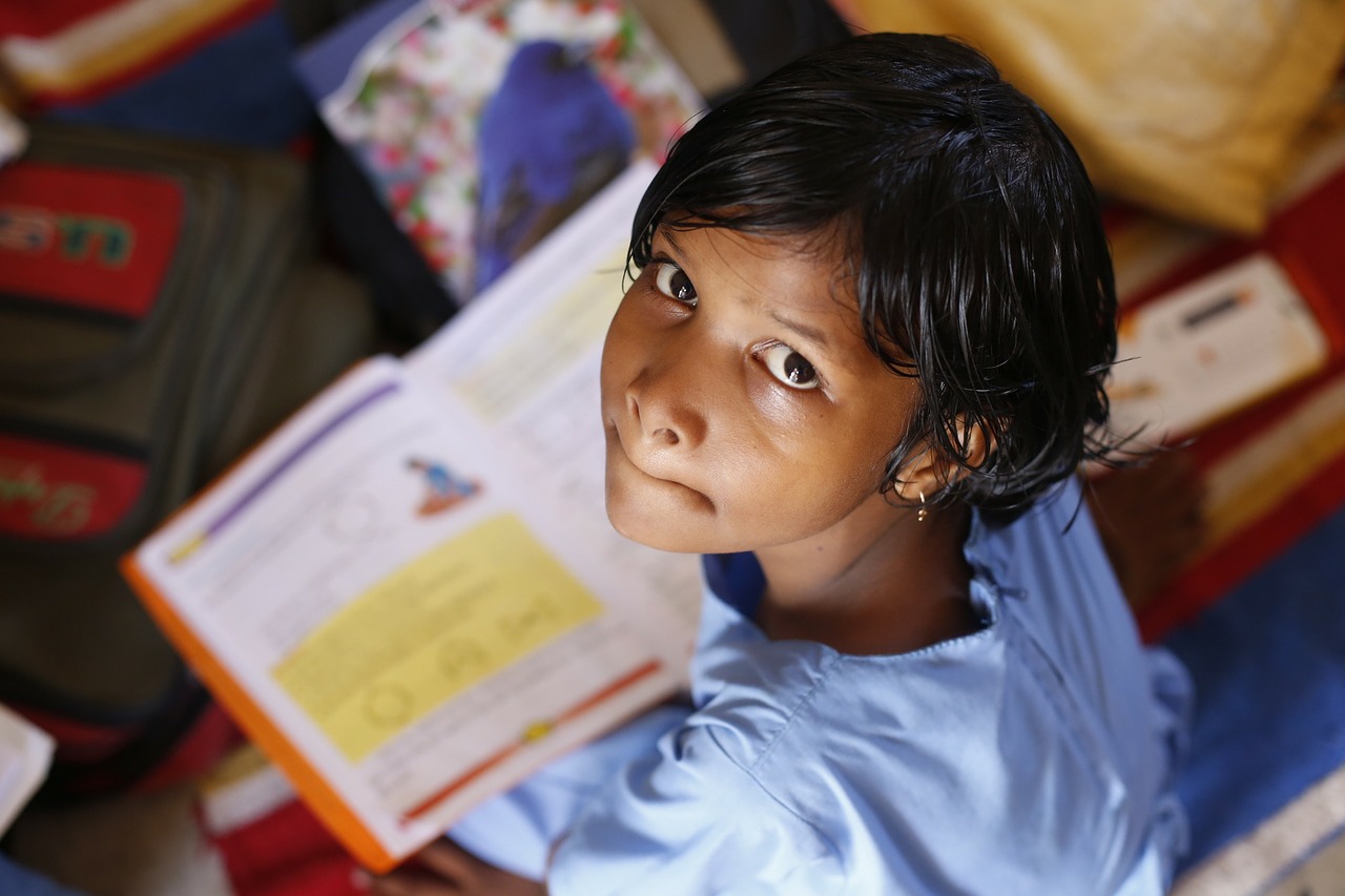 A picture of a brown girl looking up while reading